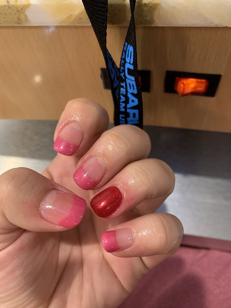 Nail technician shaping polished acrylic nails